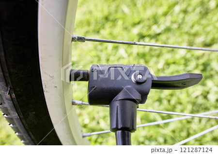 Attaching dual head nozzle adapter of air pump to bicycle valve. 121287124