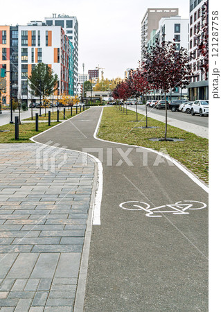Modern urban bike path with trees and buildings in background Modern urban bike path with trees and buildings in background 121287758