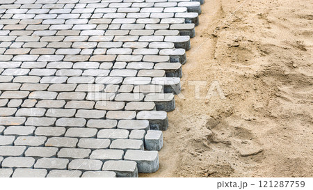 Cobblestone paving in progress on sand foundation Cobblestone paving in progress on sand foundation 121287759