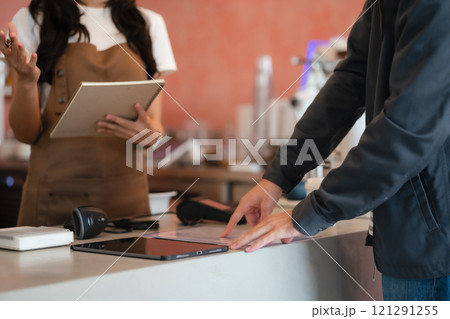 Closeup shot of cashier hands. Seller using touch smartphone for accepting client customer payment. Small business of coffee shop. 121291255