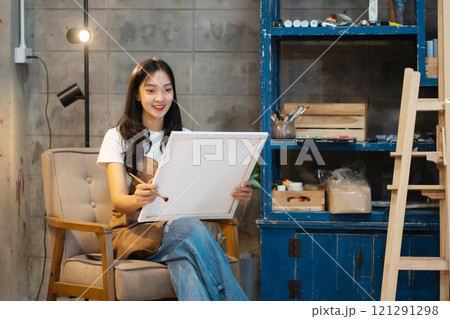 Young female artist painting on canvas in the home studio, fine arts and creativity concept. Young female artist painting on canvas in the home studio, fine arts and creativity concept. 121291298