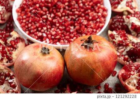 Ripe organic pomegranates and pomegranate seeds close-up Ripe organic pomegranates and pomegranate seeds close-up 121292228
