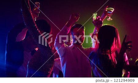 Vibrant colors, rhythmic beats, and carefree laughter create an atmosphere, for young, stylish people, of pure celebration under radiant neon lights. 121294909