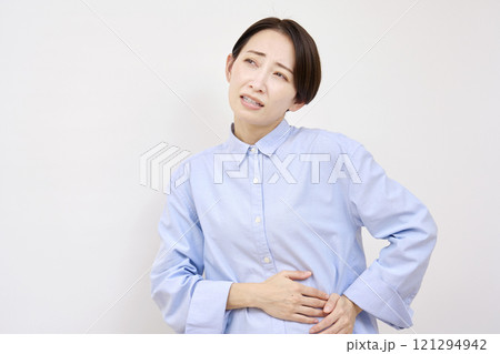 女性　腹痛　白背景 121294942