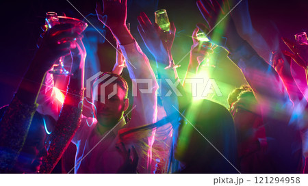 Hands wave in rhythm, glasses clinking as crowd celebrates life, music, and sharing happiness under neon lights. Hands wave in rhythm, glasses clinking as crowd celebrates life, music, and sharing happiness under neon lights. 121294958