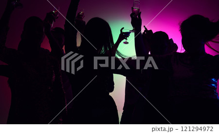 Rhythm of music fuels joy as friends celebrate with stylish moves, sparkling glasses, and neon-lit happiness in club. 121294972