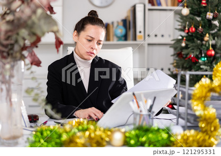 Woman manager working at computer during christmas holidays 121295331