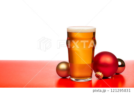 A pint glass of beer with festive Christmas baubles on a red and white background A pint glass of beer with festive Christmas baubles on a red and white background 121295831