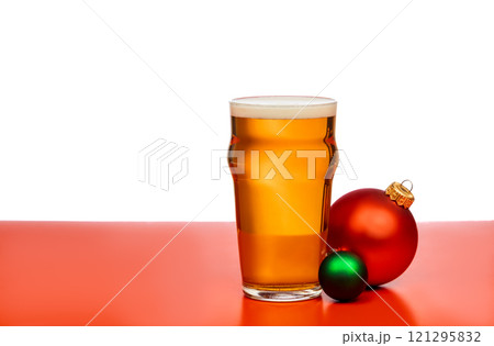 A pint glass of beer with festive Christmas baubles on a red and white background A pint glass of beer with festive Christmas baubles on a red and white background 121295832