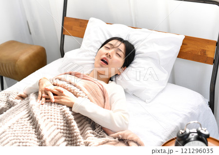 ベッドの上でいびきをかき寝るアジア人女性 121296035