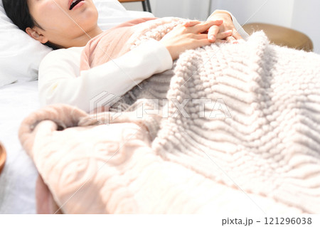 ベッドの上でいびきをかき寝るアジア人女性 ベッドの上でいびきをかき寝るアジア人女性 121296038