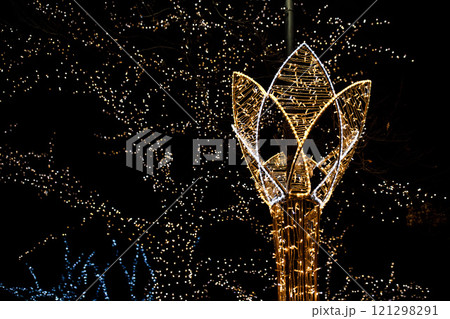Christmas lights shaping a flower illuminating the night sky Christmas lights shaping a flower illuminating the night sky 121298291