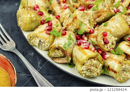 A plate of eggplant rolls. 121298424