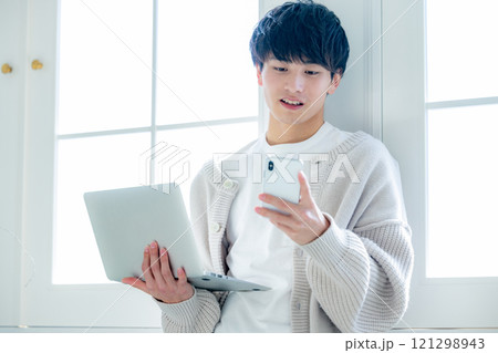 窓際でパソコン作業をする青年 窓際でパソコン作業をする青年 121298943