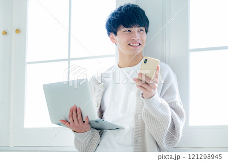 窓際でパソコン作業をする青年 窓際でパソコン作業をする青年 121298945