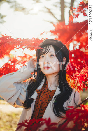 紅葉狩りをしているベレー帽を被った若い女性 121299284