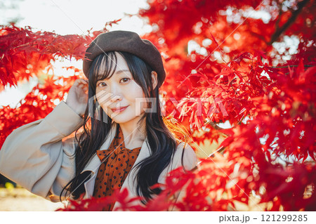 紅葉狩りをしているベレー帽を被った若い女性 121299285