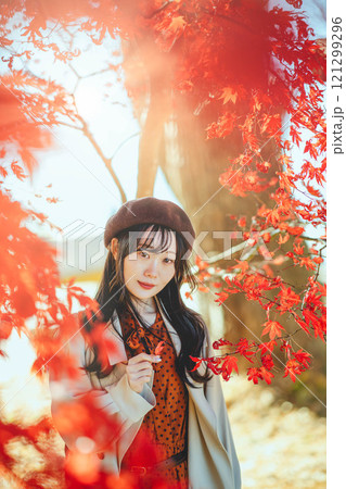 紅葉狩りをしているベレー帽を被った若い女性 121299296