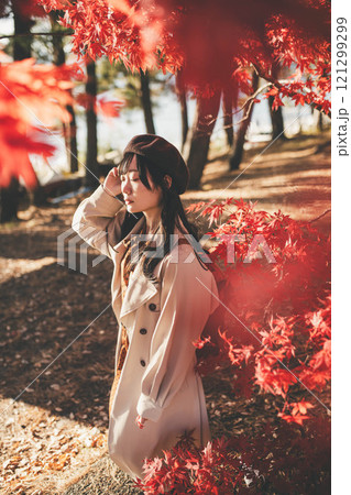 紅葉狩りをしているベレー帽を被った若い女性 121299299