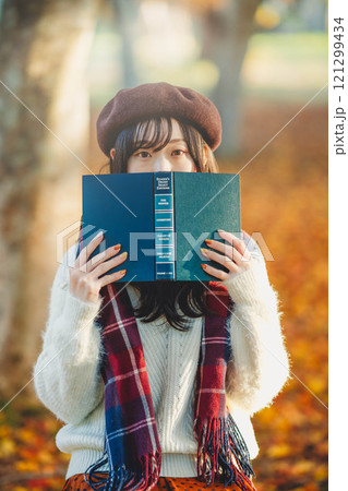 読書の秋 紅葉している公園で読書をする若い女性 読書の秋 紅葉している公園で読書をする若い女性 121299434