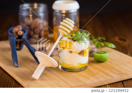 homemade yogurt with kiwi, honey and nuts in a glass on a wooden table homemade yogurt with kiwi, honey and nuts in a glass on a wooden table 121299452