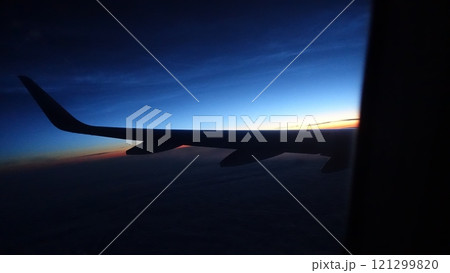 The silhouette of an airplane wing during a flight at sunset The silhouette of an airplane wing during a flight at sunset 121299820