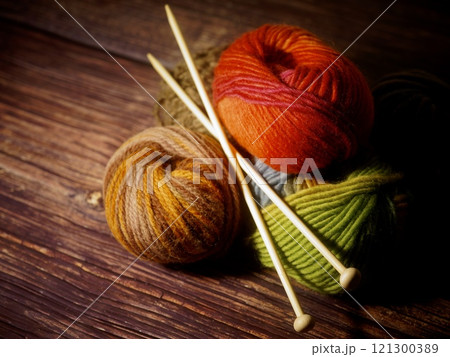 木のテーブルに置かれた毛糸と編み棒 121300389