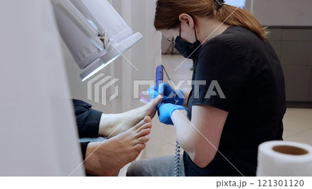 Talented podiatrist wearing protective gear performs a meticulous pedicure in a clinic, demonstrating expertise and commitment Talented podiatrist wearing protective gear performs a meticulous pedicure in a clinic, demonstrating expertise and commitment 121301120