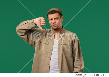 Young multiracial man with sign of dislike. European dude expressing thumbs-down 121301210