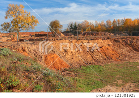Construction site in fall on sunny day in countryside. Beginning of construction site. Ground and trees. Sand and clay. Construction site in fall on sunny day in countryside. Beginning of construction site. Ground and trees. Sand and clay. 121301925