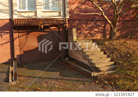 Iron gate to garage in house. Beton steps. Old building in backyard of cottage.  121301927