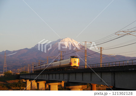 冠雪の大山の裾野に向かって日野川の橋梁を高速で駆け抜ける国鉄色381系特急やくも号リバイバル塗装車両 121302128