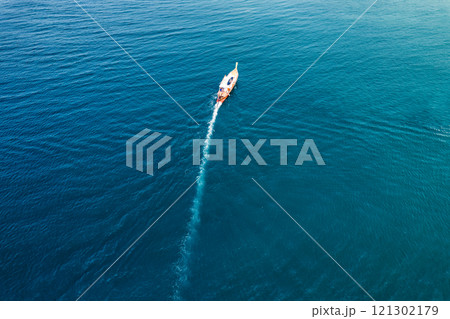 Wooden fishing boat sailing in tropical blue sea during summer on sunny day 121302179