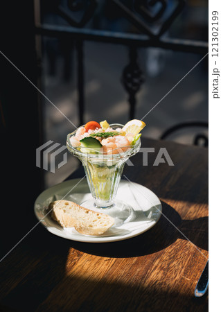 Appetizer prawn cocktail with vegetables served with brown bread in a glass Appetizer prawn cocktail with vegetables served with brown bread in a glass 121302199