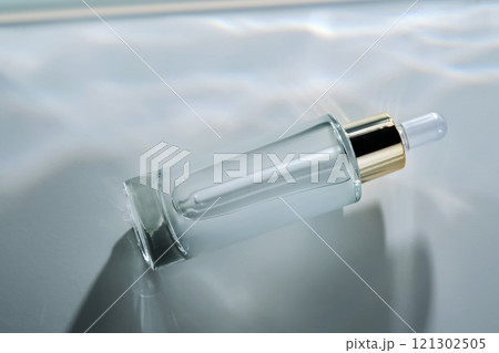 Bottle of face serum with a pipette with a beautiful highlight. Bottle of face serum with a pipette with a beautiful highlight. 121302505