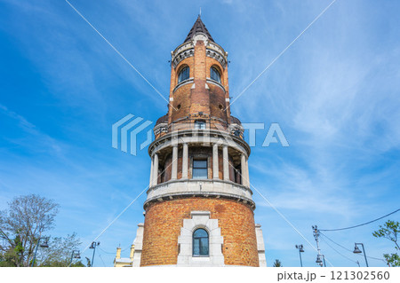 The iconic Gardos Tower stands tall in Zemun, Belgrade, surrounded by lush greenery and bright blue skies, showcasing its historical architecture and vibrant atmosphere. The iconic Gardos Tower stands tall in Zemun, Belgrade, surrounded by lush greenery and bright blue skies, showcasing its historical architecture and vibrant atmosphere. 121302560