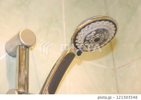 Shower head with limescale in the bathroom - close-up Shower head with limescale in the bathroom - close-up 121303548