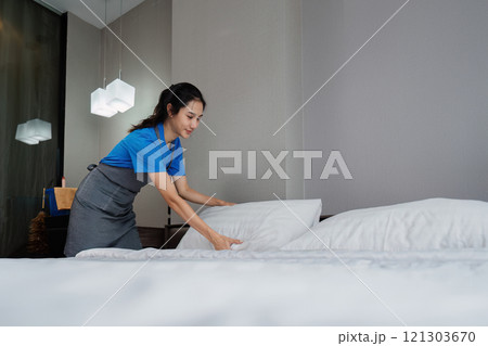 cleaning service woman worker clean bedroom at hotel. housekeeper cleaner feel happy and make bed look neat. housework and housekeeping cleaning service cleaning service woman worker clean bedroom at hotel. housekeeper cleaner feel happy and make bed look neat. housework and housekeeping cleaning service 121303670