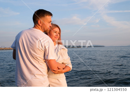 happy beautiful couple walking at sunset along the seashore happy beautiful couple walking at sunset along the seashore 121304550