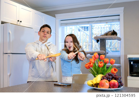 A husband wears an apron while cooking dinner with his wife. The duo took a break to sip coffee and sample the completed bread. A husband wears an apron while cooking dinner with his wife. The duo took a break to sip coffee and sample the completed bread. 121304595