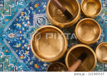 Singing Bowls on Ornate Rug 121305537