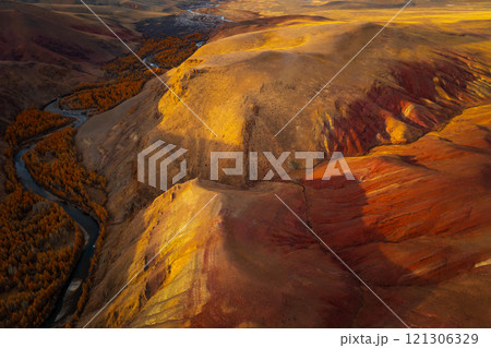 Aerial View of Vibrant Mountain Valley with Winding River in Autumn Colors 121306329