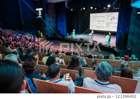 Large audience attending a presentation in a modern auditorium Large audience attending a presentation in a modern auditorium 121306402