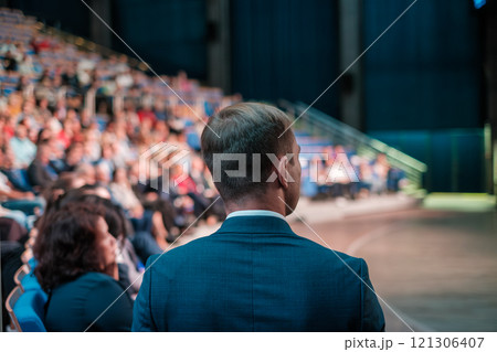 Businessman addressing audience in conference hall during presentation session 121306407