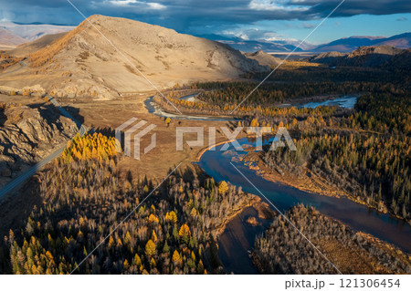 Aerial view of serene autumn landscape in Altai region with winding river 121306454
