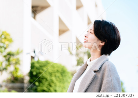 屋外を歩くコート姿の女性 121307337