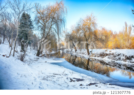 Outstanding landscape in city park with snowy trees and beautiful reflection in frozen river. Outstanding landscape in city park with snowy trees and beautiful reflection in frozen river. 121307776