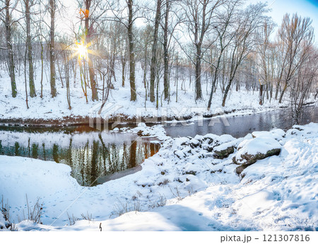 Outstanding landscape in city park with snowy trees and beautiful reflection in frozen river. Outstanding landscape in city park with snowy trees and beautiful reflection in frozen river. 121307816