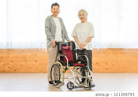 車椅子の前で話すシニア世代の夫婦 車椅子の前で話すシニア世代の夫婦 121308785