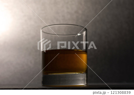 glass goblet with whiskey on a dark background 121308839